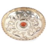 An Edward VII silver dish, embossed with a repeating pattern of six bulls, centred around a red