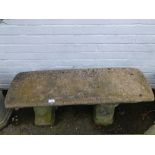 A reconstituted stone garden bench, the oblong top raised on two shaped supports 38cm high, 92cm wid