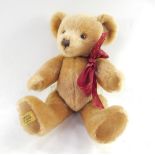 A Merrythought teddy bear, gold plush, with jointed arms and legs, button eyes and stitched snout,