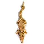 An articulated crocodile pendant, of three body detailing with head main body and tail, yellow metal