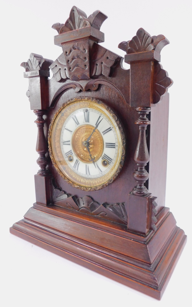 A late 19thC Ansonia Clock Company stained pine cased mantel clock, circular brass dial with enamel