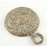 An Edward VII silver backed hand mirror, of circular form, with leaf scroll handle, inset bevelled g