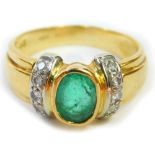 An emerald and diamond dress ring, the oval emerald in a rub over setting with tiny diamond set shou