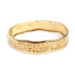 A 9ct gold waved and hammered hinged bangle, the wave design outer thick border with central hammere