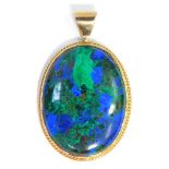 A oval stone set pendant, the green and blue oval stone in a rope twist rub over yellow metal border