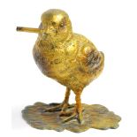 Am early 20thC cold painted lead figures, of a chick, modelled standing holding a twig in its beak,