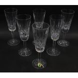 A set of six Waterford crystal champagne flutes decorated in the Lismore pattern.