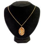 A 9ct gold oval portrait locket, with hammered floral decoration, on a 9ct gold curb link chain, the