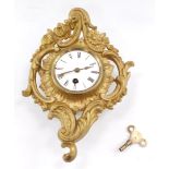 A late 19thC Continental gilt metal cartel wall clock, of rococo form, circular enamel dial bearing