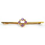 An Edwardian bar brooch, with central circular design set with four seed pearls and four amethysts,