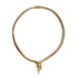 A 9ct gold snake designed choker, the spring articulated body with gold head and tail, set with garn
