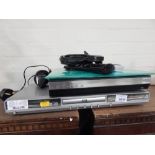 A Dual DVD player and a Humax Freeview player, with wires, remote control and other accessories. (a