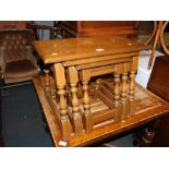 A reproduction oak nest of three joint tables.