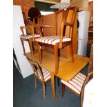 An oak extending dining table and four chairs, including two carvers with Regency stripe upholstery.