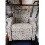 An electric reclining chair, upholstered in floral material.