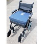 A collapsible wheelchair, with aid cushion.