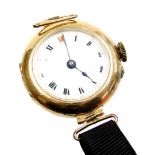 An early 20thC 9ct gold cased wristwatch, with a small circular enamelled dial with Roman numerals a