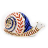 A Royal Crown Derby snail paperweight, with silvered button, 8cm high, 13cm wide.