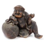 A Chinese terracotta figure of a seated man, 24cm high, 26cm wide.
