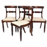 A set of four George IV mahogany dining chairs, each with curved and carved back and drop in cream u