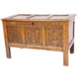 A carved oak coffer, the three panelled top above a carved front on stiles, 68cm high, 108cm wide, 5