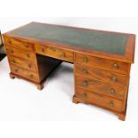 A mahogany pedestal desk, with four long drawers to each side and single drawer to centre with green