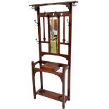 An Art Nouveau walnut hall stand, with top shelf and hanging hooks with central rectangular mirrored