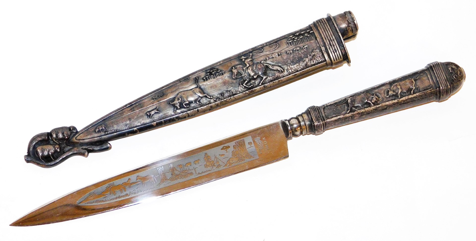 An Inox hunting knife, in a silver plated scabbard, heavily embossed with cattle scenes, of cows, bu
