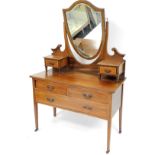 An Edwardian mahogany and marquetry banded dressing table, with shield back mirror above two side dr