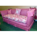 A Knole style three seater sofa, in a red upholstery, with brass acorn finials and ties, 80cm high,