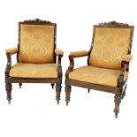 A pair of George IV rosewood library open armchairs, with scrolling cresting rails, padded backs and