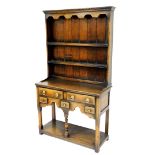 An oak dresser, in the 18thC style, with two plate shelf, the base with two long and three short dra