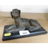 A metal figure of a seated dog on marble base, 12cm high, 18cm wide.