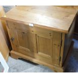 A pine low cupboard, with single two panelled door, 59cm high, 66cm wide, 49cm deep.