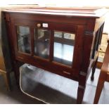 A stained mahogany display cabinet, with four glass sides, each with panelled doors, on tapering
