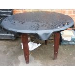 A wooden circular outdoor table, with protective cover, 117cm wide.