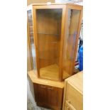 A teak corner unit, with sectional two shelf top, above two cupboard door base.