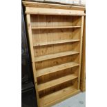 A pine bookcase, with six shelves, moulded cornice on a plinth base, 98cm high, 113cm wide, 31cm