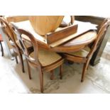 A walnut finish extending dining table and four associated chairs.