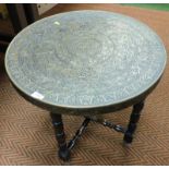 An Indian or Burmese brass table, the circular brass inlaid top on folding square base, 59.5cm