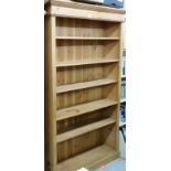 A pine bookcase, with six shelves, moulded cornice on a plinth base, 98cm high, 113cm wide, 31cm