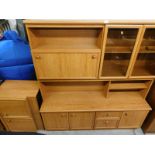 A teak finish wall unit, with bookcase cocktail section, and three cupboards and two drawers to