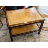 A mahogany two tier coffee table, with carved scroll supports, 44cm high, 66cm wide, 45cm deep.