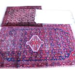 A collection of three rugs, to include a Persian Kayam type rug with an all over design, on a red gr