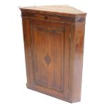 A 19thC oak and mahogany hanging corner cabinet, with a moulded cornice above a panelled door, inlai