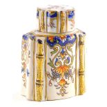 A French faience tea caddy and lid, decorated with leaves, scrolls and flowers, within simulated bam