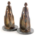 A pair of bronzed metal cast bookends, each modelled in the form of an Art Deco nude lady standing b
