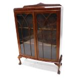 An early to mid 20thC mahogany bowfronted display cabinet, with a raised back above two glazed doors