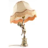 A silver plated brass table lamp, modelled in the form of a putto on a cylindrical base with shade,