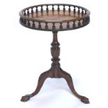 A mahogany occasional table, the circular top with a spindle turned gallery on a turned part fluted